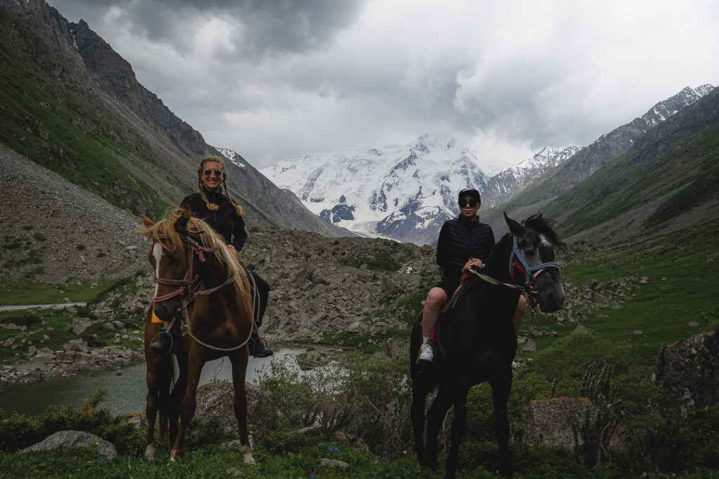 guests riding horses to karakol peak during storm kyrgyzstan
