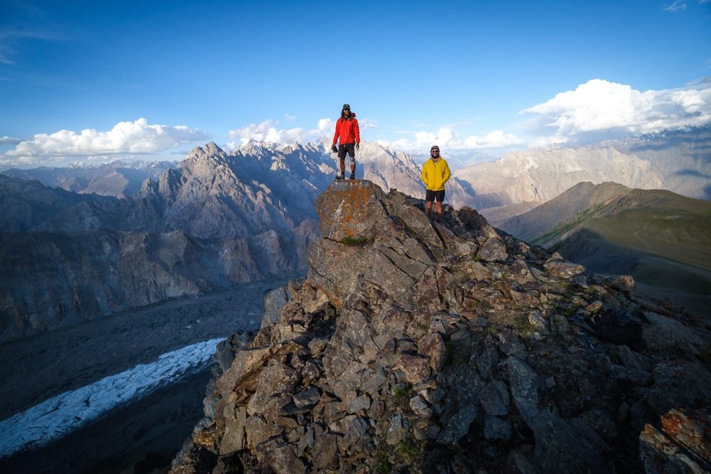 two hikers standing on top of a mountain in pakistan