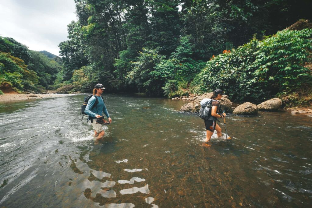 Trekkers walking over a river in PNG