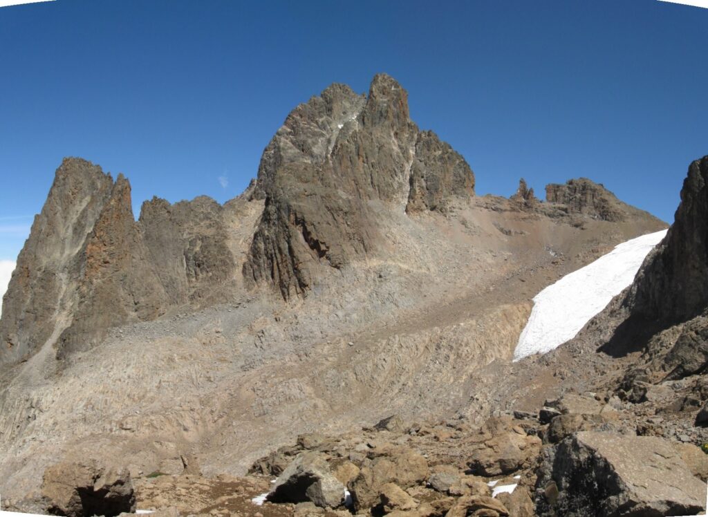 Rocky summit towers of Mount Kenya with a small glacier below the peaks